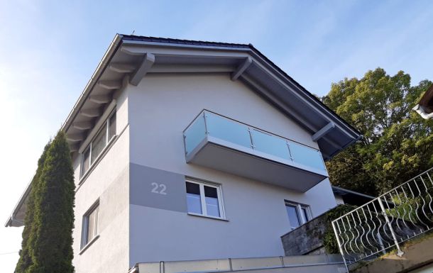 Metallbau Hofmann - Balkongeländer in Edelstahl mit Glasfüllung und Verblendung der Betonkannte mit Edelstahlblech